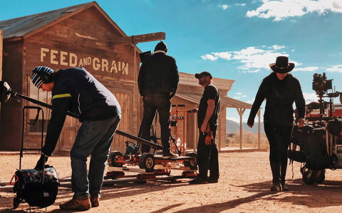 Equipe montando trilho de câmera em locação de faroeste