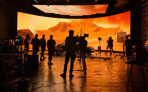 Equipe filmando diante de um painel de LED em estúdio de produção virtual